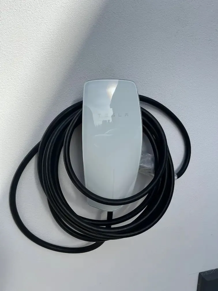 Cargador Tesla instalado en la pared de un garaje