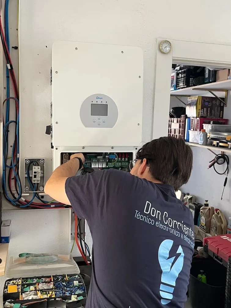 Electricista de Don Corriente, de espaldas, conectando un inversor solar
